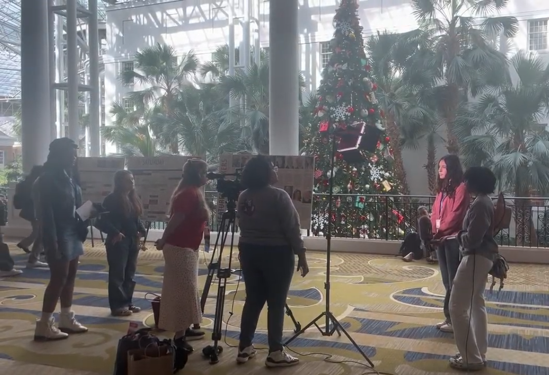 Fellow journalism students at NSPA film content for their respective publications outside the convention hall doors. Photo by Shanon Woolf