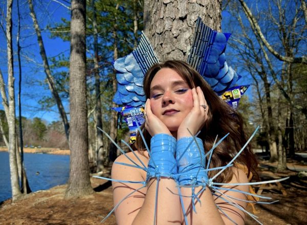 Annaliese Black posing in her Sea of Plastics dress made of only collected recycled materials.