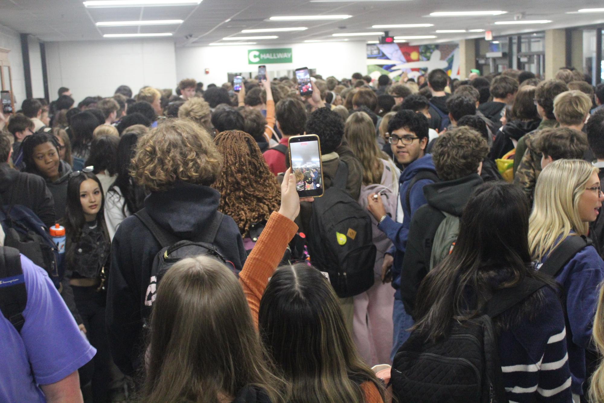 Students passing through the lobby during the class change from fourth to fifth period, at 1:05 p.m. Some are checking out to join the protest while others pass through the hallway on their way to class.