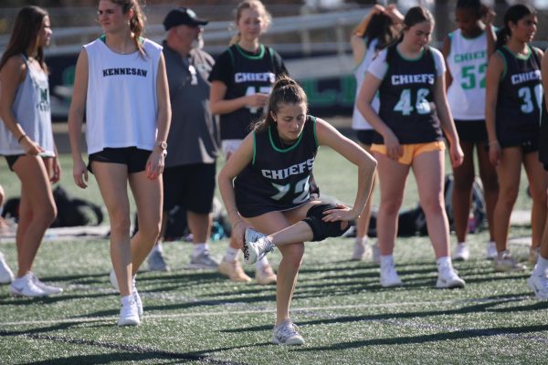 Alonso stretches on the field during practice while she waits with her team. Image courtesy of Savannah Wright.