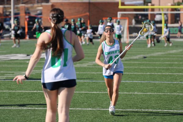 Lacrosse player Angeline McComb approaches another player on the field. Image courtesy of Savannah Wright.