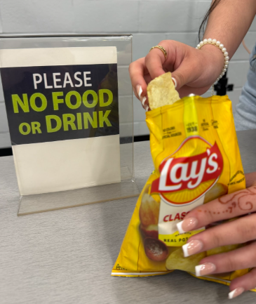 Poster sign in media center glass classroom to remind students not eat in class 