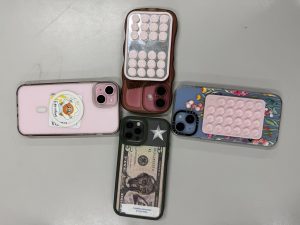 Four student phones placed together on a table away from students.