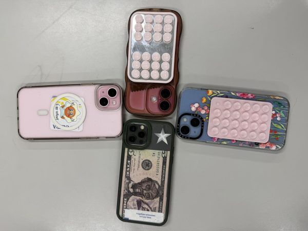Four student phones placed together on a table away from students.